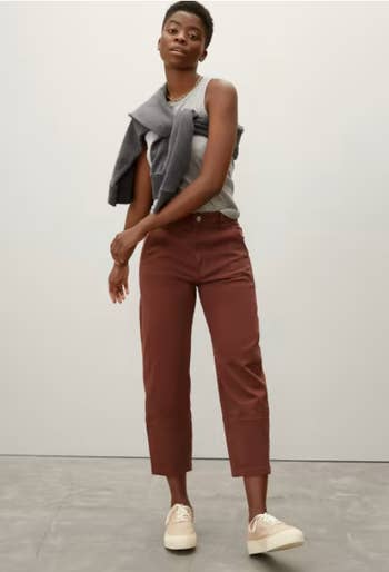model wearing the reddish brown pants with a tank and tennis shoes