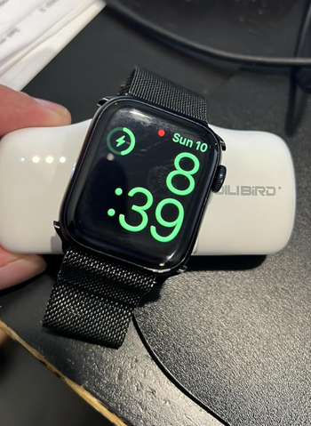 A black smartwatch on a charging dock