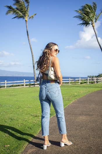 reviewer in same style jeans in a light wash, plus a crop top and block-heel sandals