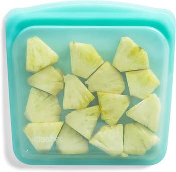 Pineapple chunks stored in a reusable Stasher bag, suitable for shopping and food storage