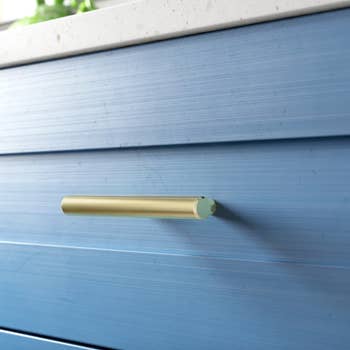 gold handle bar on blue dresser drawer
