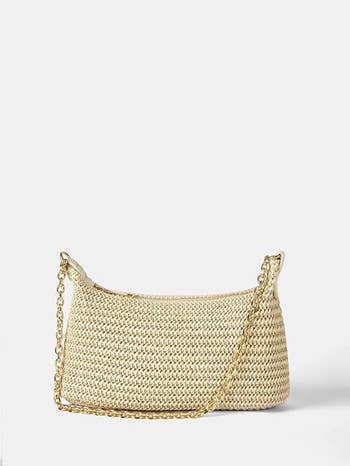 Straw handbag with a concatenation  strap, featured arsenic  a stylish accessory successful  a buying  article