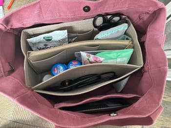 same reviewer's handbag with organized compartments showing tissues, gum, sunglasses, and personal items inside