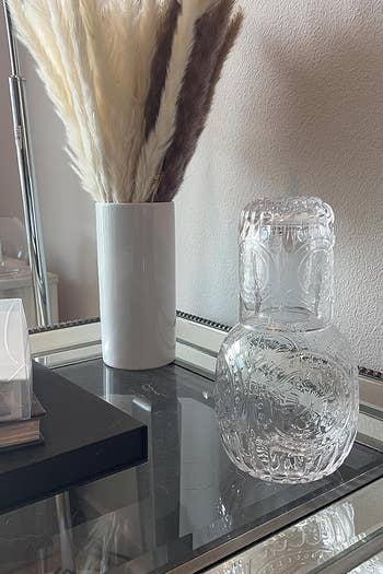 reviewer's carafe beside a flower vase
