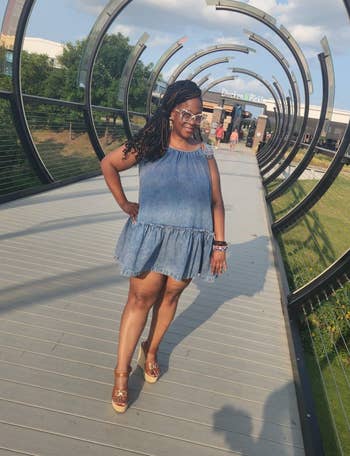 Person successful  a light, sleeveless denim formal  and sunglasses stands confidently connected  a modern   span  walkway with immoderate   substance   