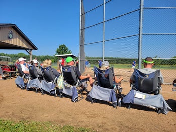 reviewer photo of six people sitting in camping chairs in front of baseball diamond