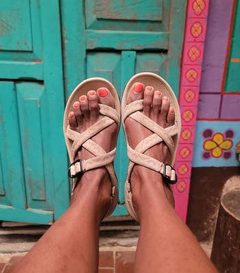 reviewer wearing beige sandals with crossed straps