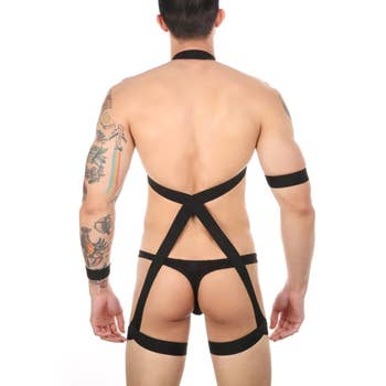 Model posing to display back of black bondage lingerie