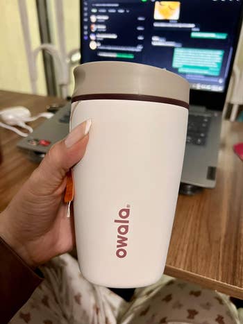 reviewer holding the FreeSip shown from the broadside with a beverage container sticking out
