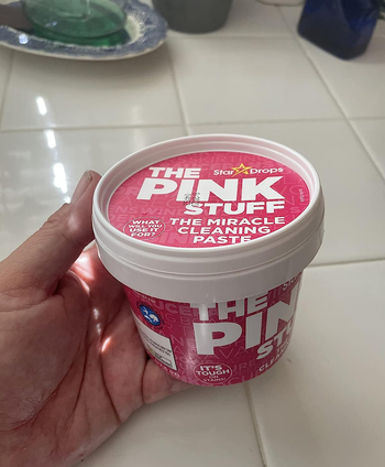 reviewer holding container of the pink stuff