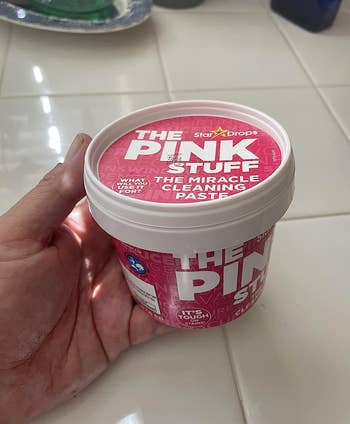 reviewer holding container of the pink stuff