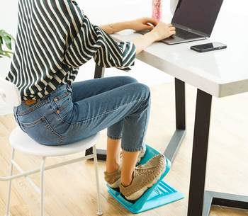 model using a blue footrest under a desk