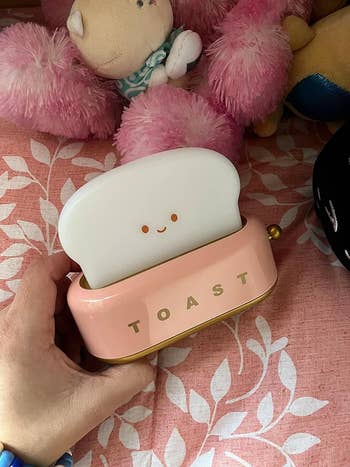 image of reviewer holding up   the tiny  pinkish  toast lamp