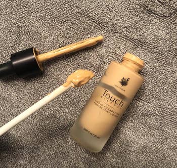 reviewer photo of the spatty being used to get foundation out of the jar