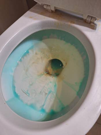 Toilet with a cleaning solution and stains, likely illustrating a cleaning product test or review for household shopping