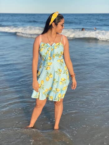 a reviewer at the beach wearing the light blue sundress