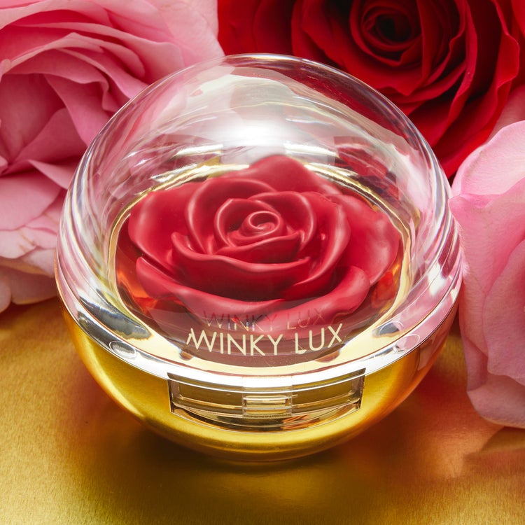 rose shaped blush in reddish shade in a spherical compact with gold bottom and clear top