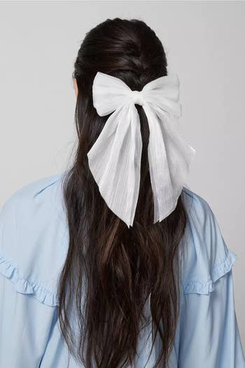 a model wearing a white hair bow 