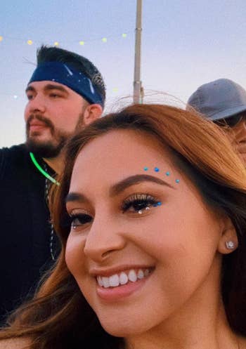 another reviewer wearing blue and clear gems above their brows