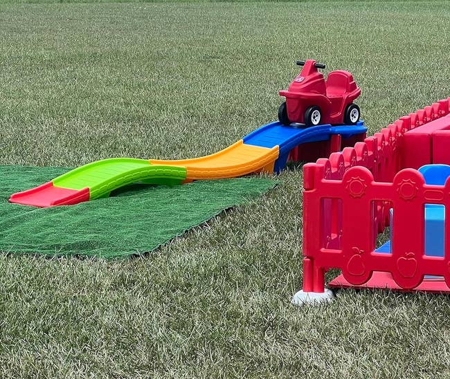 Children's outdoor playset with a slide and climbing section on grass