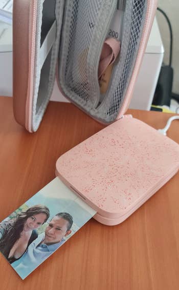 Reviewer image of small compact pink printer with image of a couple printed from it 