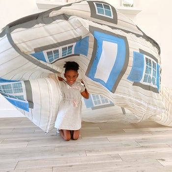 child flipping over an inflatable house fort from the inside