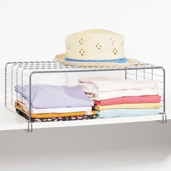 Wire rack placed above folded clothes
