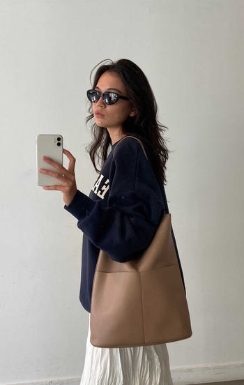 a model holding the beige purse