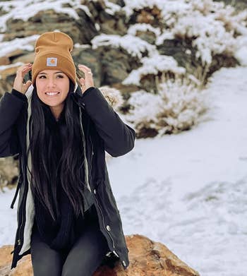 reviewer wearing the tan beanie in the snow