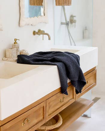 a dark gray waffle towel draped over a bathroom counter