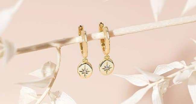 The earrings with gold ovals dangles with a cubic zirconia starburst
