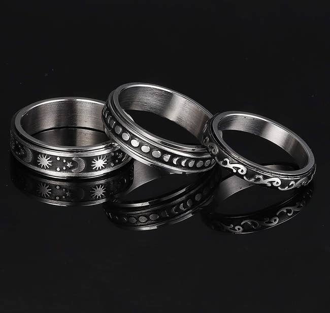 silver colored rings with moving bands with moons and stars