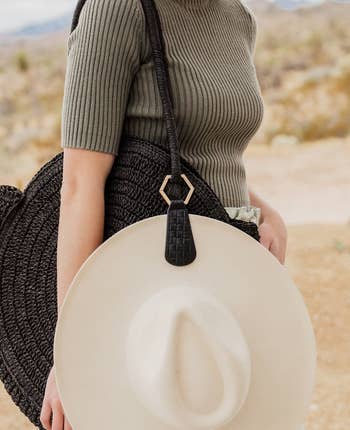 model with hat clipped to their purse using Toptote clip
