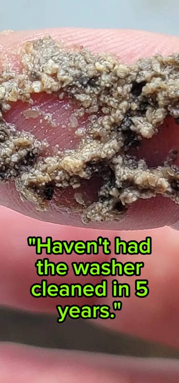 Close-up of a digit  holding a clump of grime with substance   stating, 