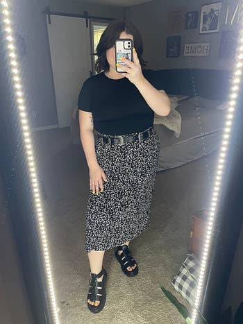 Reviewer wearing the black midi skirt with an abstract white print