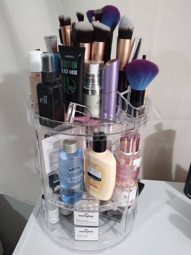 Rotating cosmetics organizer filled with various beauty products and brushes