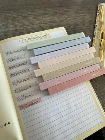 Open notebook with pastel-colored highlighters and cursive 