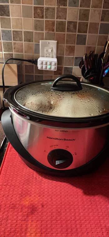 A reviewer's crockpot plugged into the timer plug