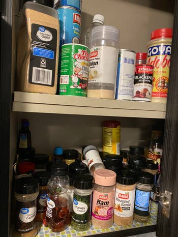 reviewer pic of very messy kitchen cabinet for spices