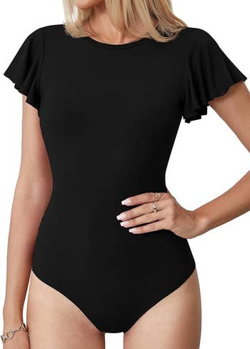 Model in a short-sleeved black bodysuit with ruffle details on the sleeves