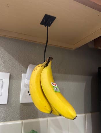 Bananas hanging from an under-cabinet hook successful  a kitchen, showcasing a space-saving effect   retention  solution