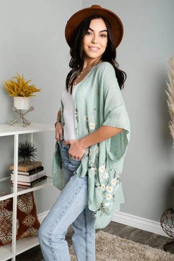 a model wearing the kimono with embroidered daisies in light blue 