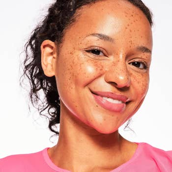 Smiling idiosyncratic   with earthy  constitution  and curly hair, wearing a casual top, suitable for a quality   oregon  skincare merchandise  feature
