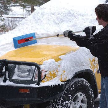 a model using the broom to push snow of the front of a truck 