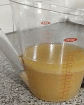 reviewer gif of the fat separator holding liquid with a thick layer of fat on top