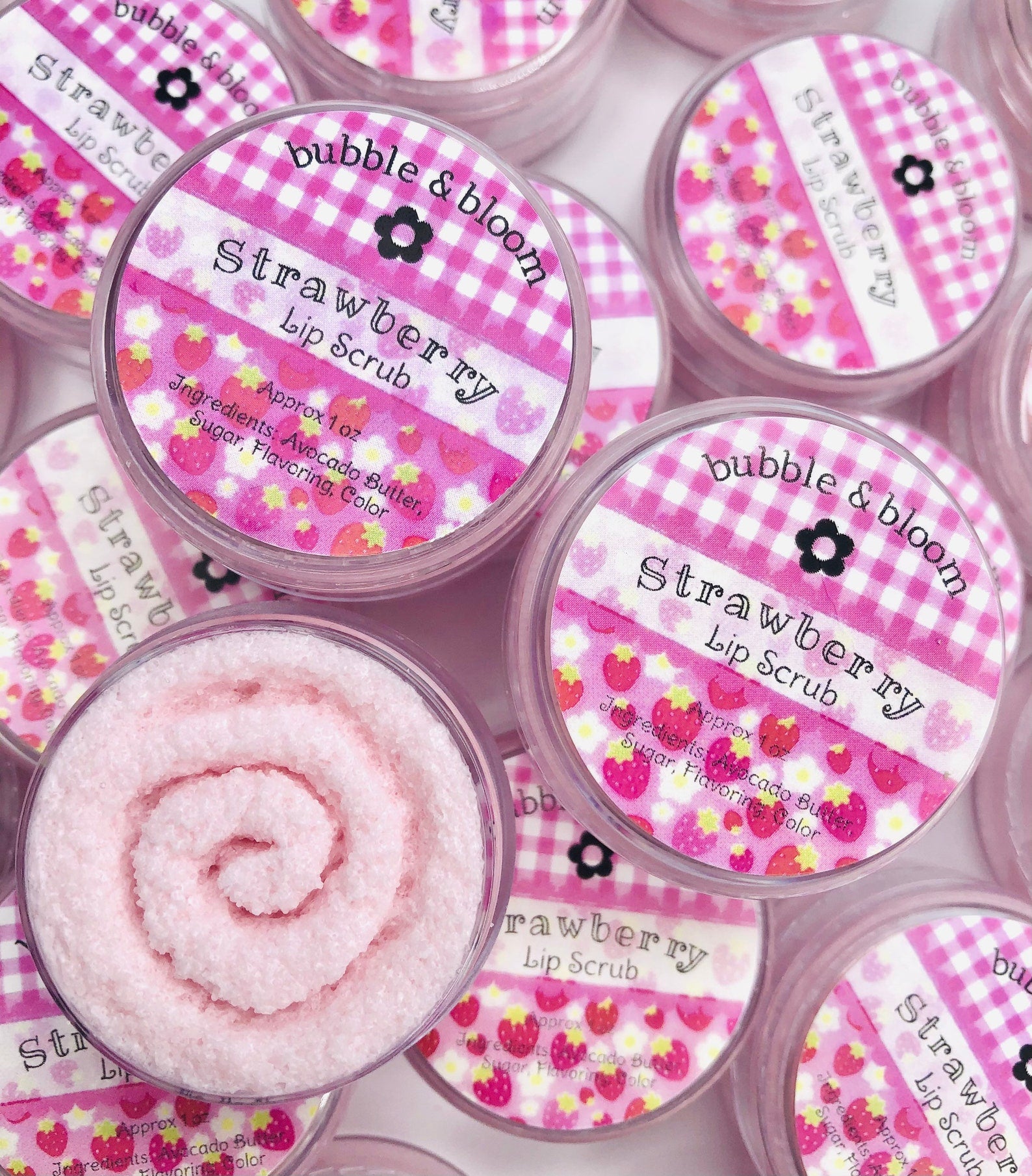 A small container of strawberry-colored  lip scrub 