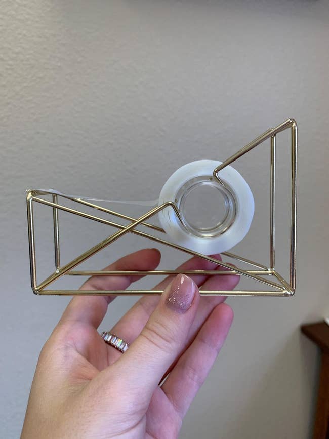Person holding a golden geometric portion dispenser