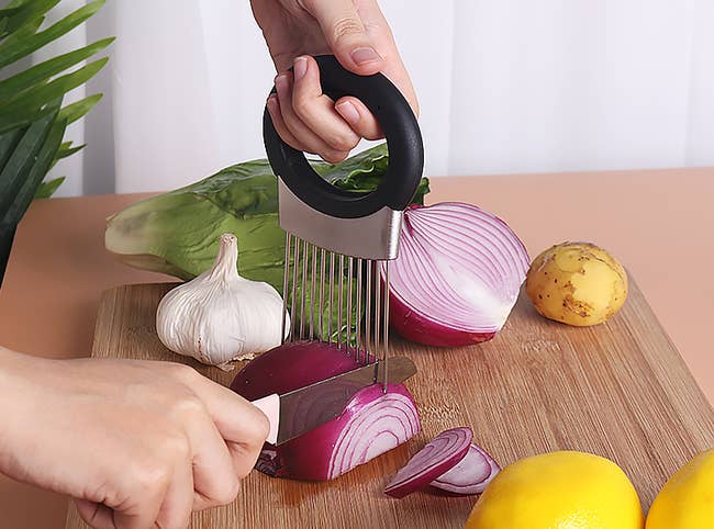 a model using the onion holder in one hand and the other using a knife to cut