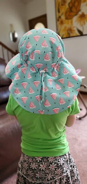 A child wearing the hat in blue with a watermelon pattern