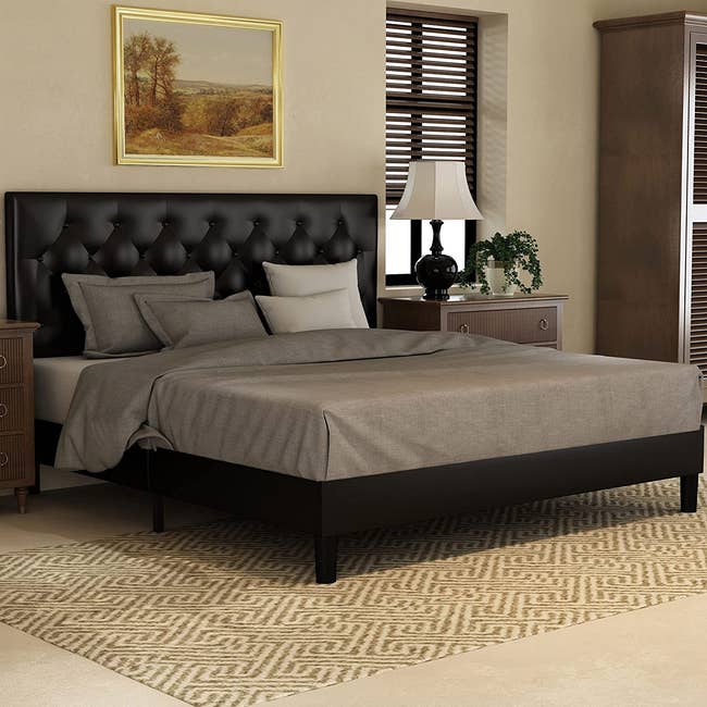 a black faux leather upholstered bed